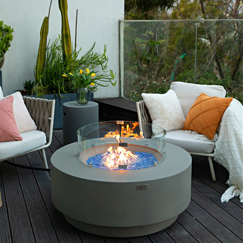 Elementi Plus Colosseo Round Gray Concrete Fire Table on Patio with Glass Wind Guard