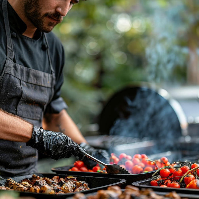  A man is outside grilling food on a grill preparing a meal