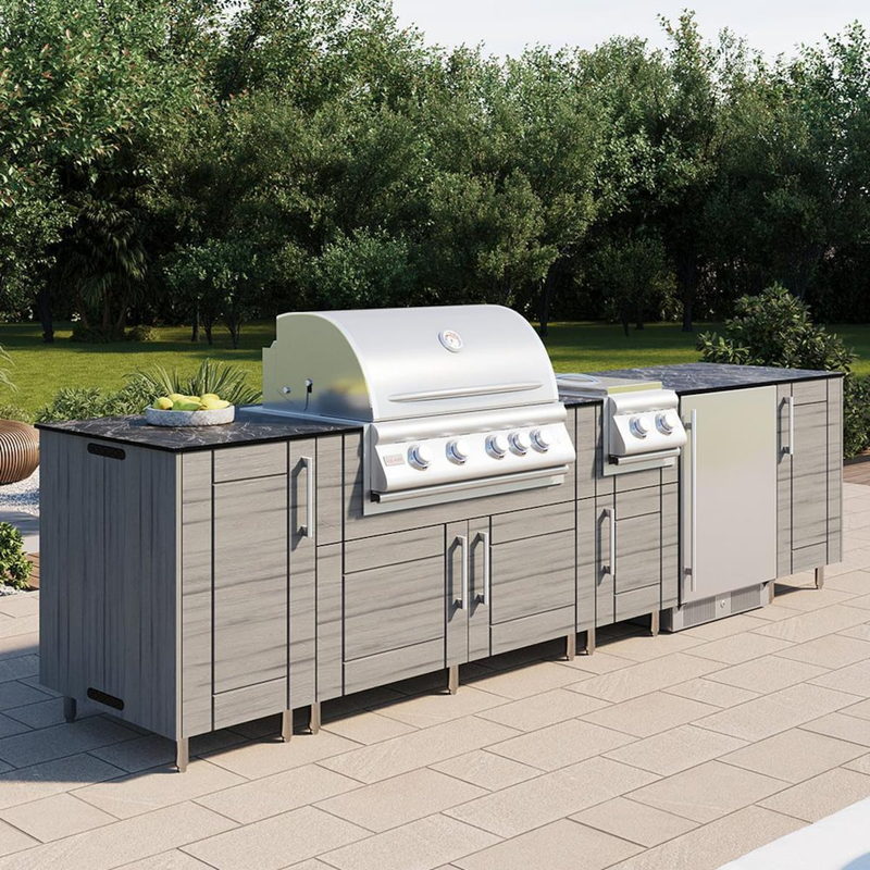 WeatherStrong Bimini Dark Ash outdoor kitchen island with Blaze grill and refrigerator in a backyard