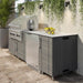 WeatherStrong Bimini Dark Ash outdoor kitchen island with Blaze grill and refrigerator on a covered patio