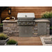 Wildfire Ember 32-inch stainless steel gas grill built into a stone and wood outdoor kitchen island.