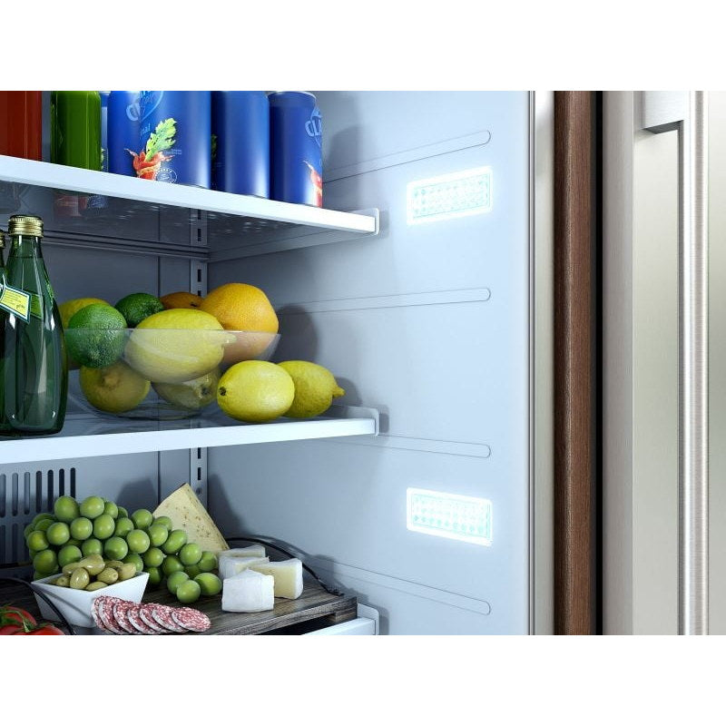 Close-up of the Zephyr Presrv outdoor refrigerator interior showing produce and bottles on an LED lit glass shelf.
